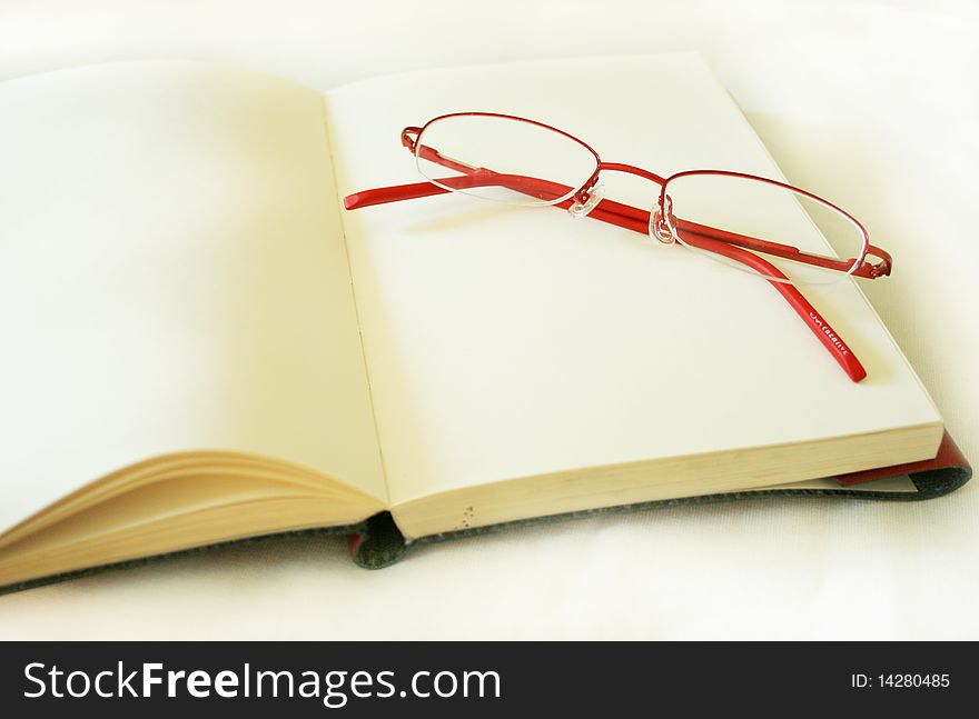 Notebook made of a red skin and glasses. Photo taken on May 10th,2010.