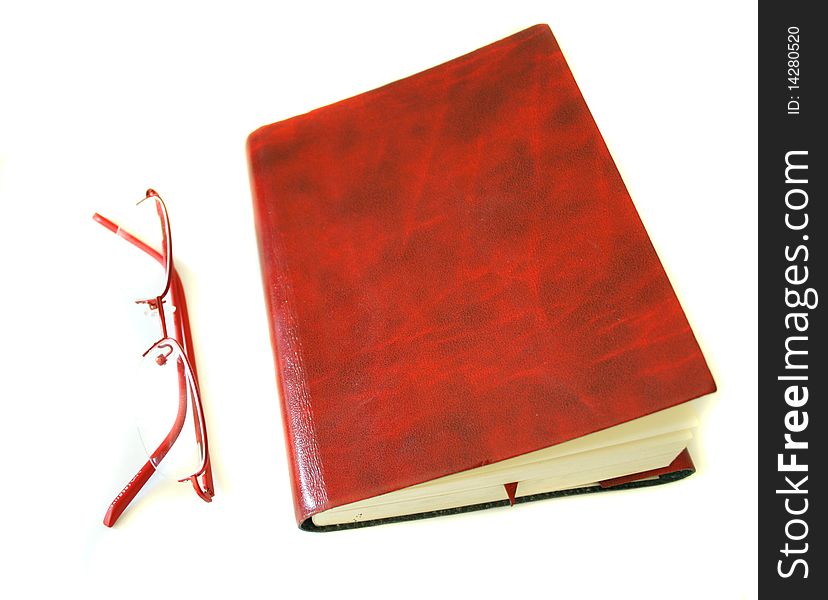 Notebook made of a red skin and glasses. Photo taken on May 10th,2010.