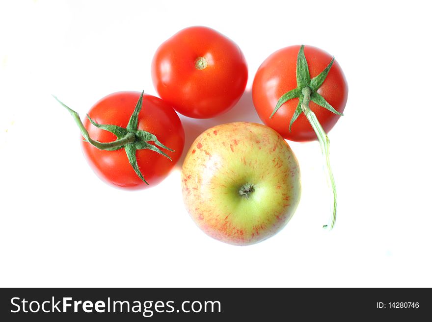 Three ripe tomatoes and apple isolated on a white background. Photo taken on May 10th, 2010.