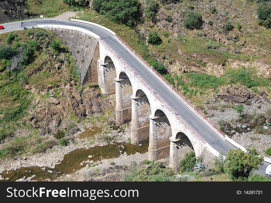 Old stone arches bridge on a countryside road. Old stone arches bridge on a countryside road