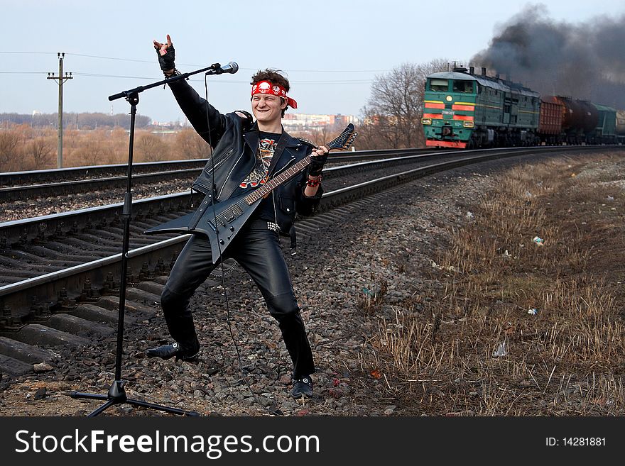 Young rock star welcomes fans while a train is approaching from behind. Young rock star welcomes fans while a train is approaching from behind