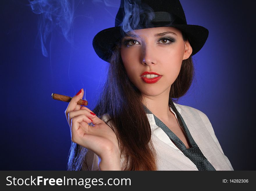 Beautiful young woman smoking cigar. Beautiful young woman smoking cigar