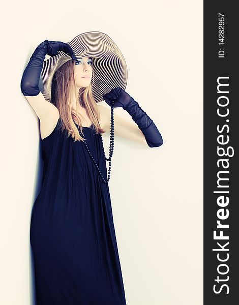 Portrait of a beautiful girl in elegant black dress and a hat. Portrait of a beautiful girl in elegant black dress and a hat.
