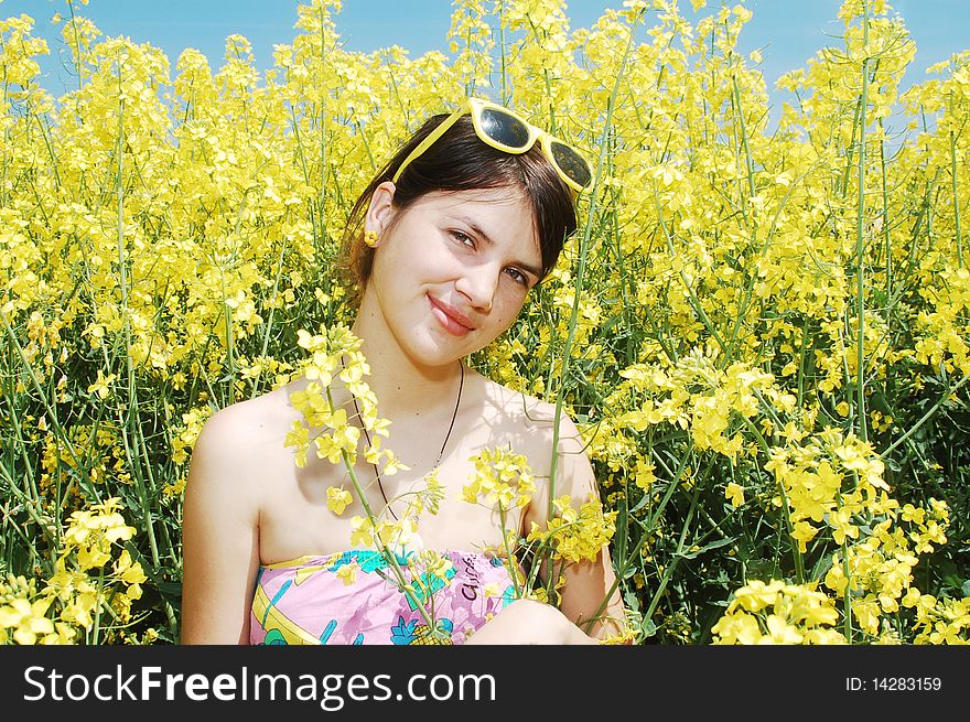 Young beautiful girl enjoying a sunny day on rapeseed flower field. Young beautiful girl enjoying a sunny day on rapeseed flower field