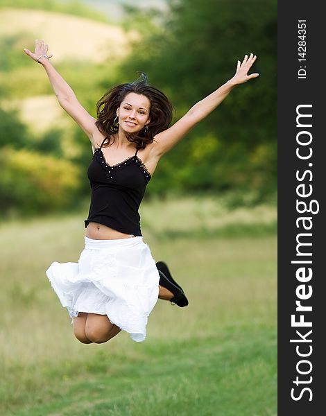 Jumping girl in green meadow