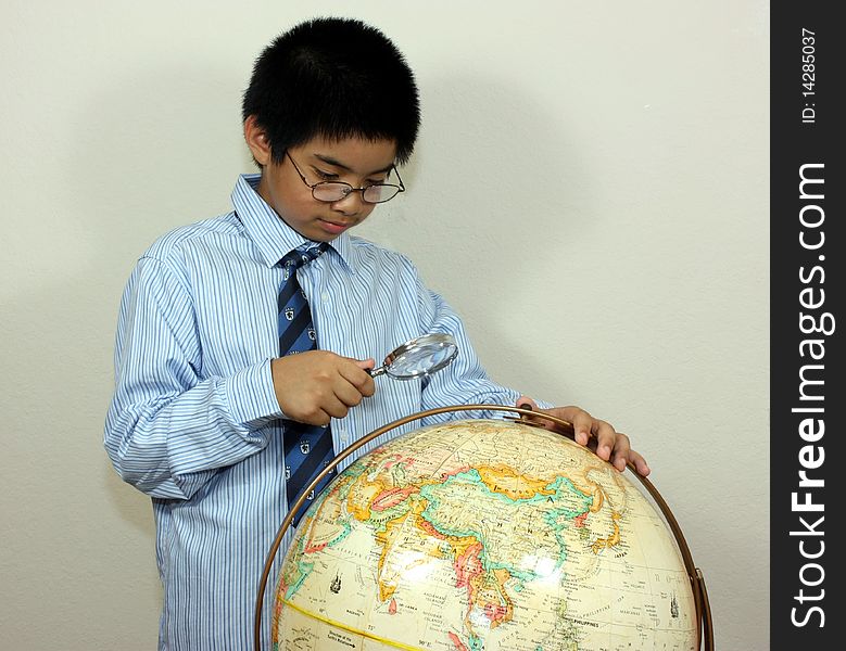 A Boy Examining A Globe