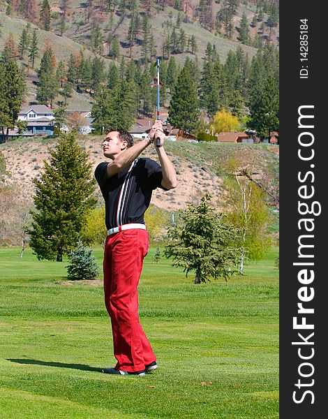 Young golfer following his ball after a shot from the fairway