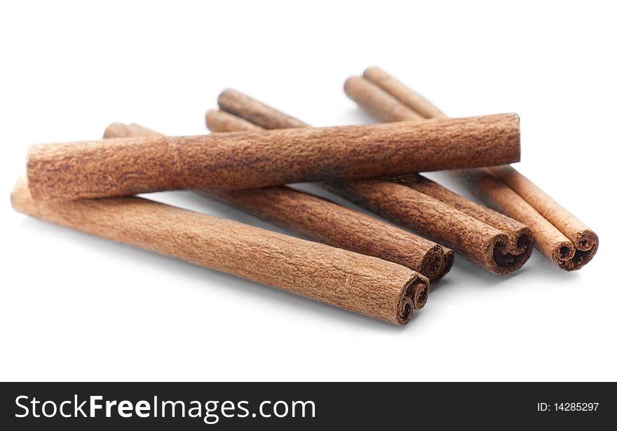 Close-up of cinnamon sticks on white background with minimal shadow.