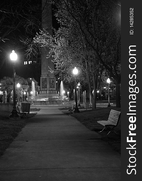 A side walk in a city park at night. A side walk in a city park at night.