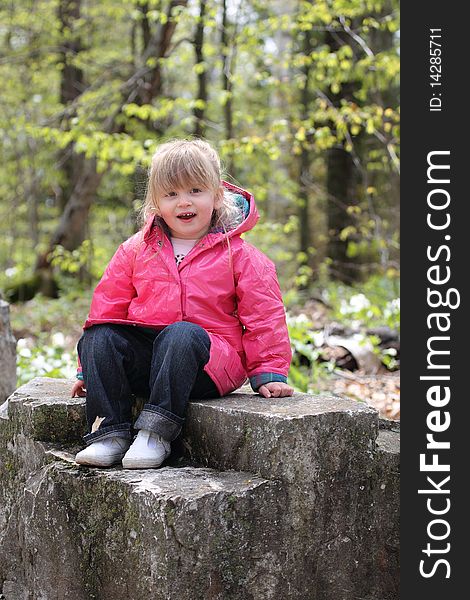 Happy Little Girl Sitting on Rock