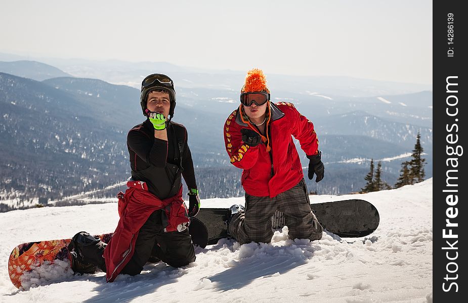 Two snowboarder blow a kiss on mountain