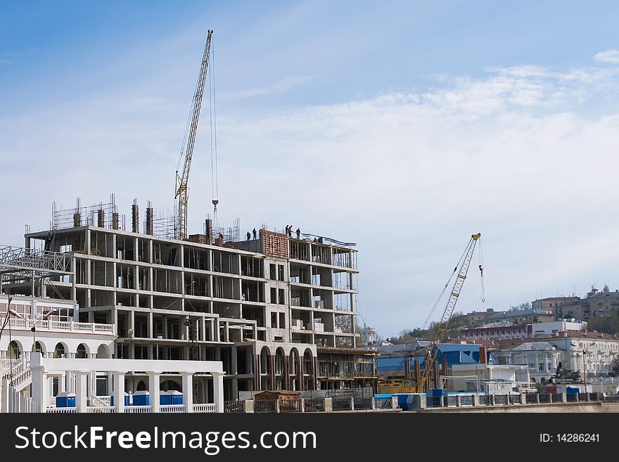 Crane Near Building On Cloudy Sky Background