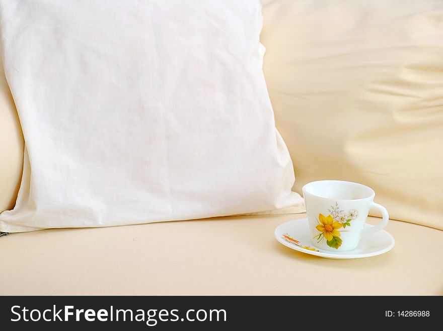 Closeup of cup on sofa with cushion. For relaxation and lifestyle concepts.