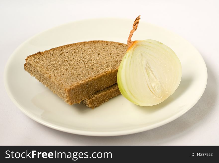 The bread and onions at white plate close-up on a white background. The bread and onions at white plate close-up on a white background