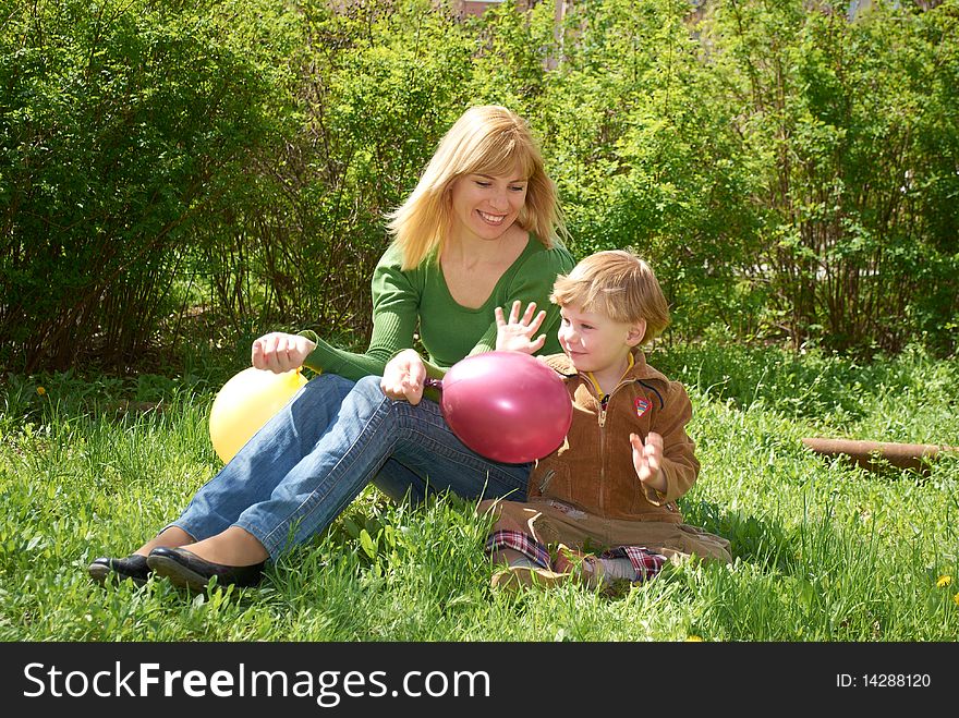 Mum with the son are played with balls in the spring on the nature. Mum with the son are played with balls in the spring on the nature
