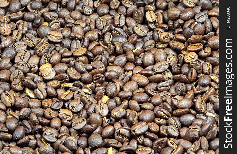 Birds-eye view of roasted coffee beans spread out to form a background. Birds-eye view of roasted coffee beans spread out to form a background