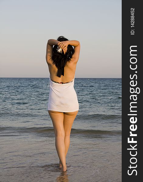 Young woman with flower enjoys the sea. Young woman with flower enjoys the sea.