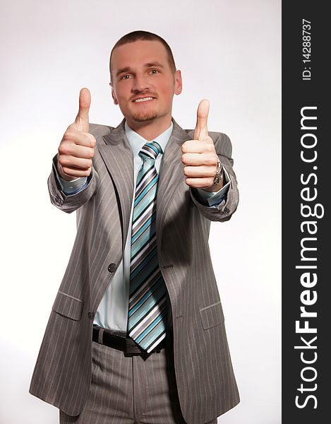 Young businessman in suit giving thumbs up. Young businessman in suit giving thumbs up