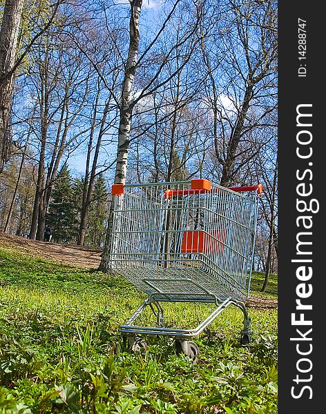 The hand cart from a supermarket on a green grass close up