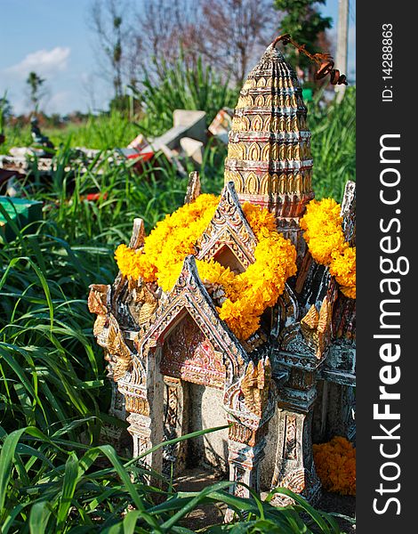 Old ruin spirit house with yellow flower on grass ground. Old ruin spirit house with yellow flower on grass ground