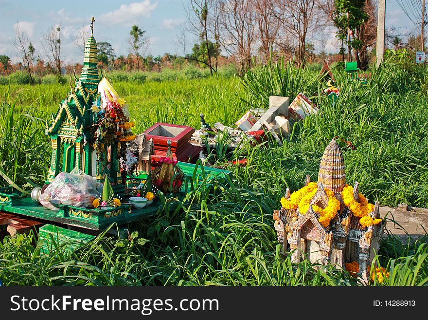 Old ruin spirit house with yellow flower on grass ground. Old ruin spirit house with yellow flower on grass ground