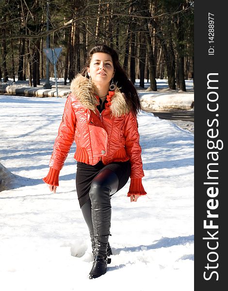 Happy girl walking outdoor in a snowdrift in winter