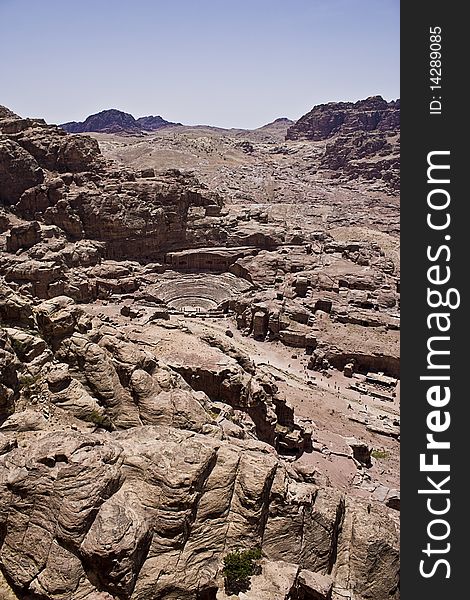 Photo of Roman theater behind beautiful rock formations, taken in a sunny day over a clear blue sky. Photo of Roman theater behind beautiful rock formations, taken in a sunny day over a clear blue sky