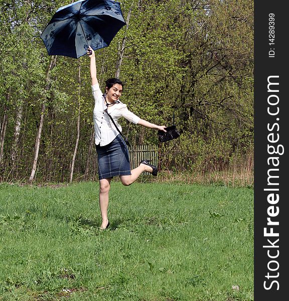 Business woman jumping with umbrella
