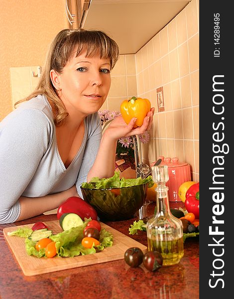 Adult woman preparing salad at domestic kitchen