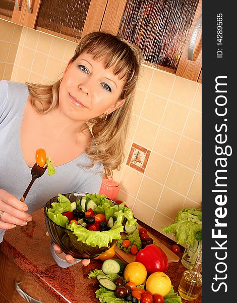 Adult woman preparing salad at domestic kitchen. Adult woman preparing salad at domestic kitchen