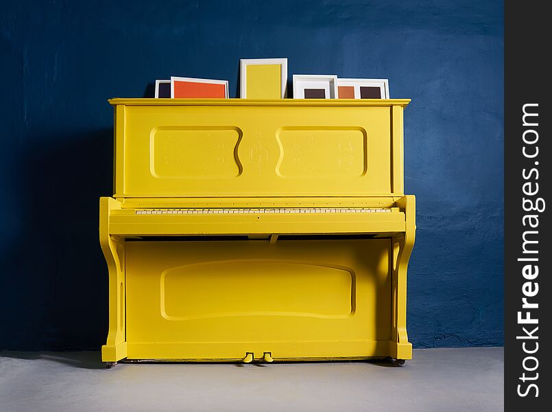 Old yellow piano on blue  happy. Old yellow piano on blue  happy