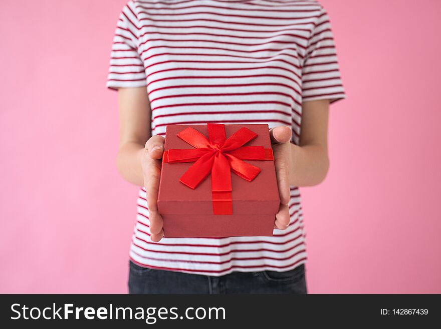 The girl holds in her hands a red box with a gift. The girl holds in her hands a red box with a gift.