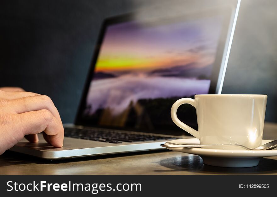 Espresso coffee in a cup of hot coffee with hot steam and smoke,man hands is working,using a computer,boy fingers typing on the