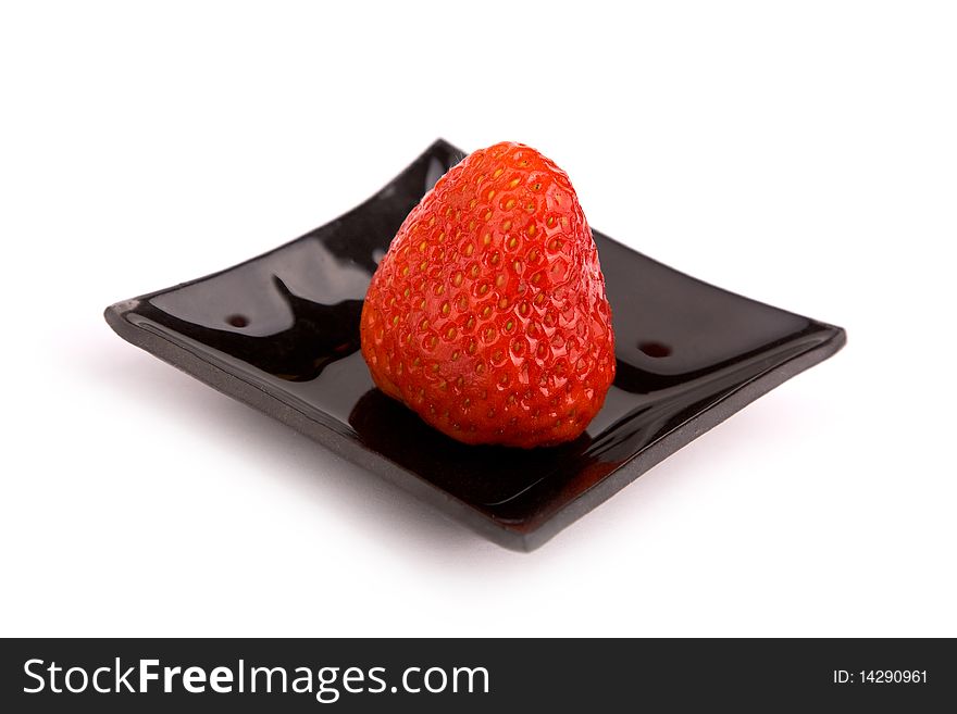 Strawberry on black plate isolated on white background