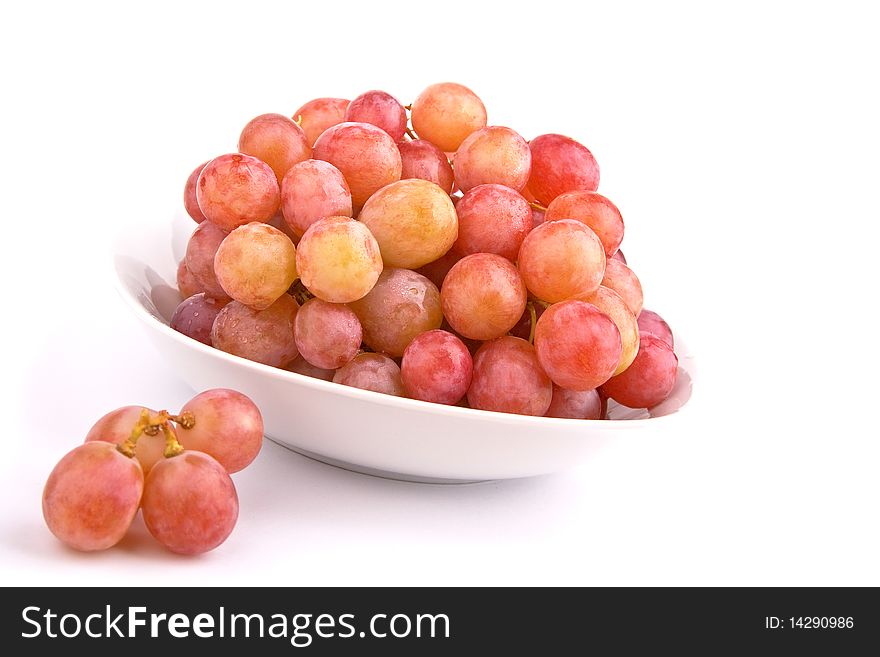 Red grapes in a bowl isolated on white background. Red grapes in a bowl isolated on white background