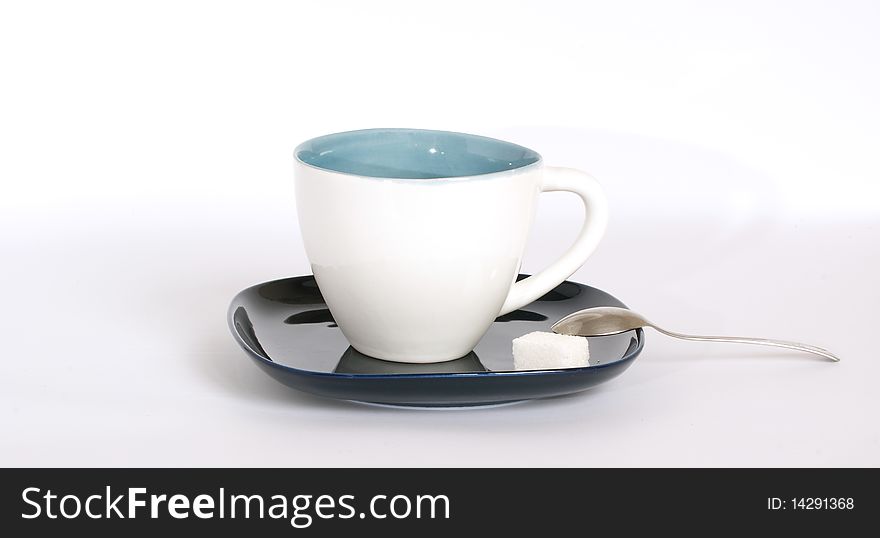 White tea cup with a spoon on the saucer, on a white background