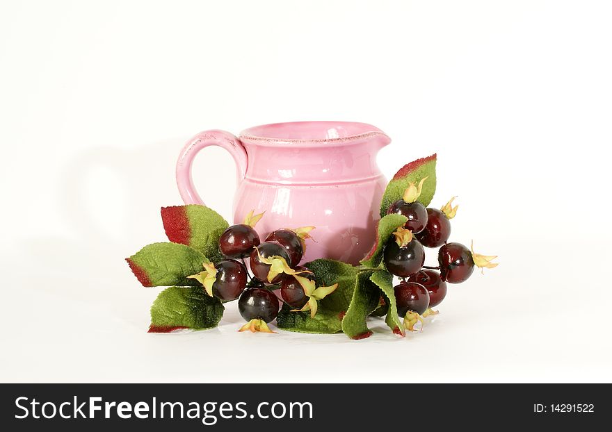 Pink ceramic jar with a sprig of souvenir berries, isolated