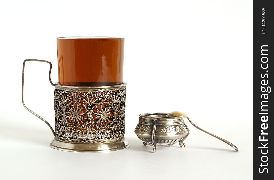 A glass of tea with a silver holder, isolated on a white background