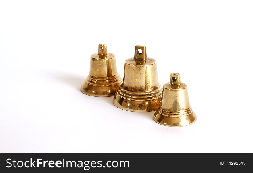 Small brass bells on a white background with shadows