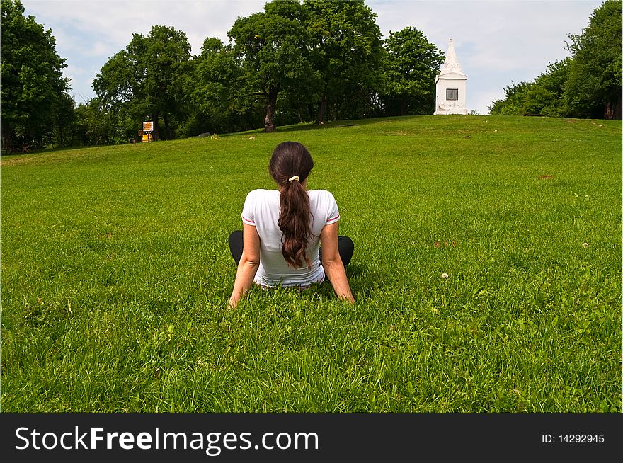 Young woman, sitting on the grass, enjoying nice spring weather outdoors. Young woman, sitting on the grass, enjoying nice spring weather outdoors
