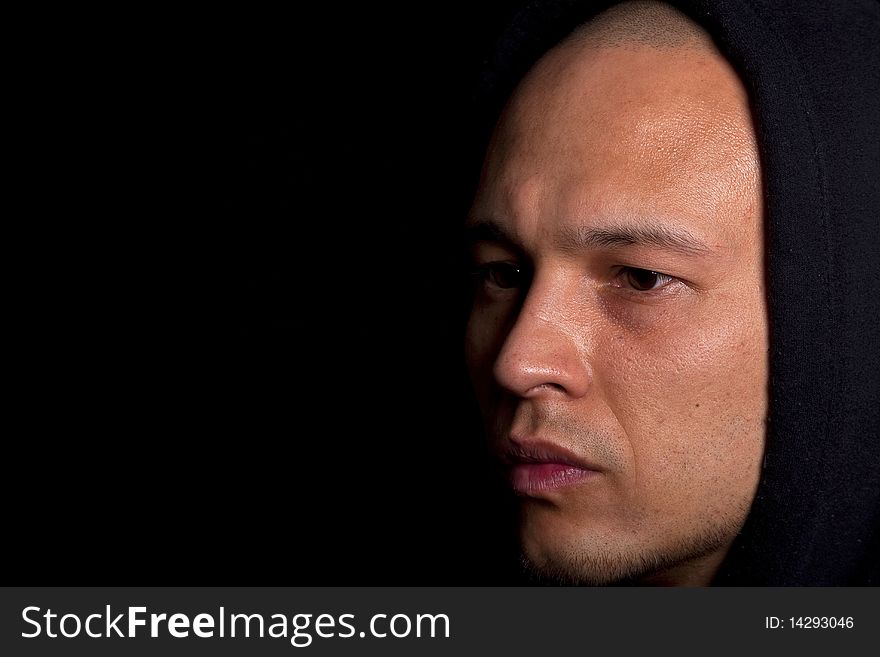 Stylish young man with hoddie over a black background.