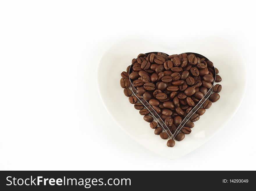 Coffee beans in the form of heart, on white background