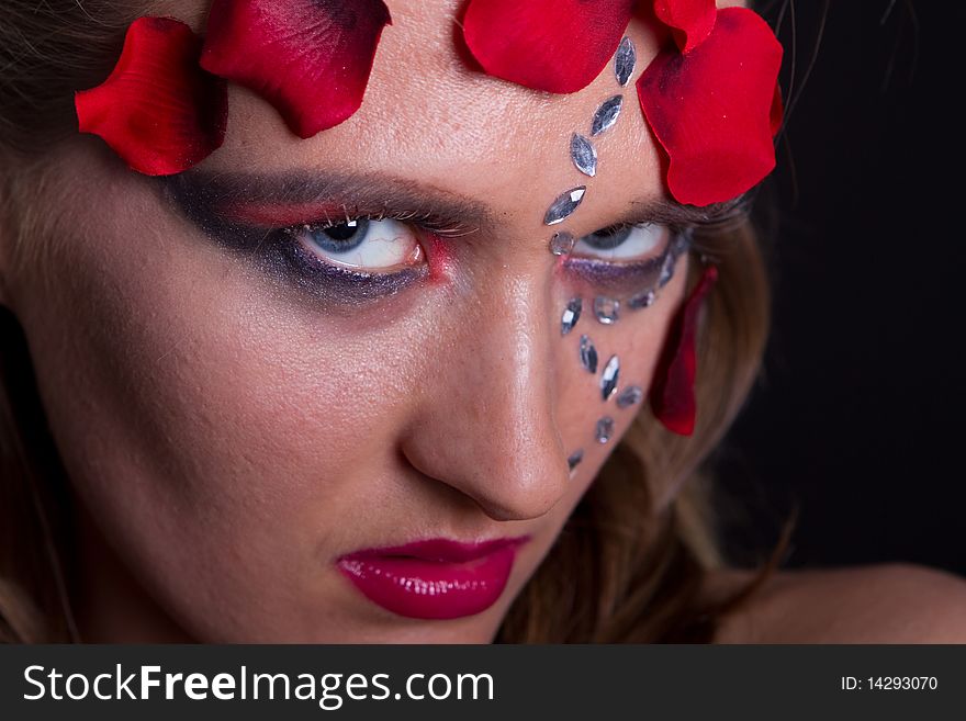 Young fresh woman with an extreme and glamorous makeup and roses on her face. Young fresh woman with an extreme and glamorous makeup and roses on her face.