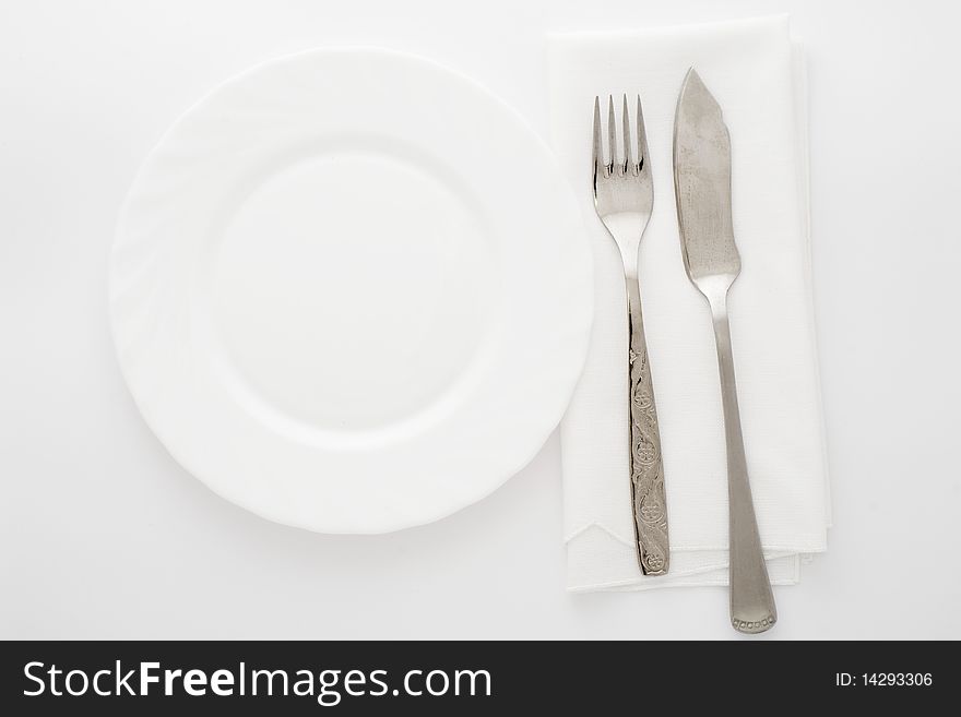 An image of white plate and knife with fork. An image of white plate and knife with fork