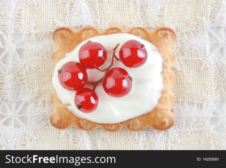 Dessert. Cake with red currant in sour cream on the white patterned napkin