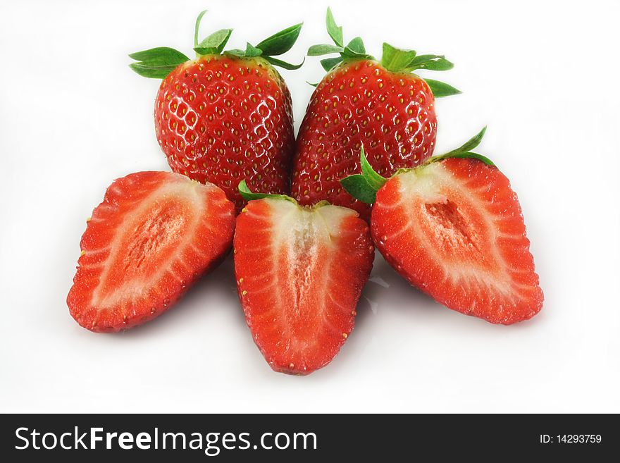 Whole and sliced strawberries closeup on white background