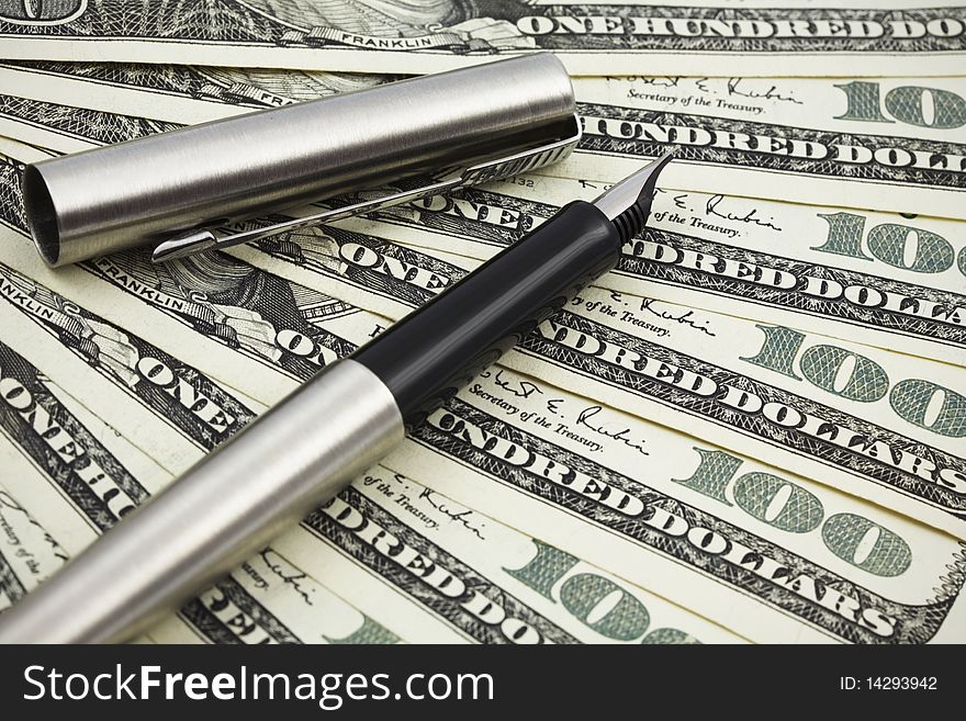 Silver pen on the background of the dollar banknotes. Silver pen on the background of the dollar banknotes