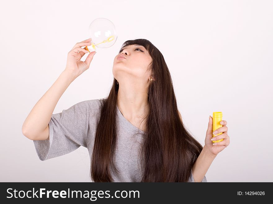 Girl blowing soap bubbles in studio