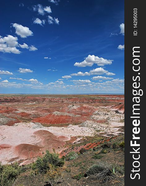 This landscape of the Painted Desert in northern Arizona contains traveling clouds and colorful sediment converging to the center of the photo. The Painted Desert appears predominantly red because of the abundant iron and manganese compounds found in the sediment.