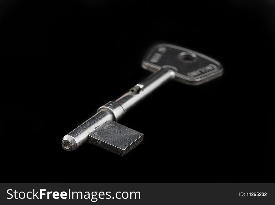 Silver blank key isolated on a black background. Silver blank key isolated on a black background